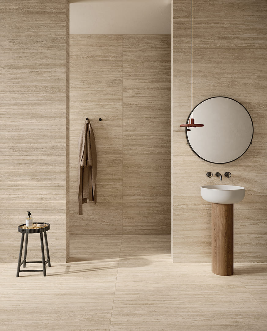 Badkamer met beige travertinlooktegels en een wand met fijne lijnen uit Pastorelli New Classic